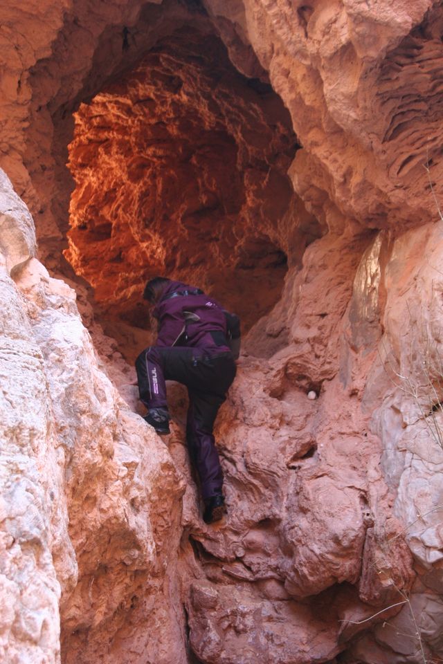 Amanda climbing through a cave-tunnel in Havasu