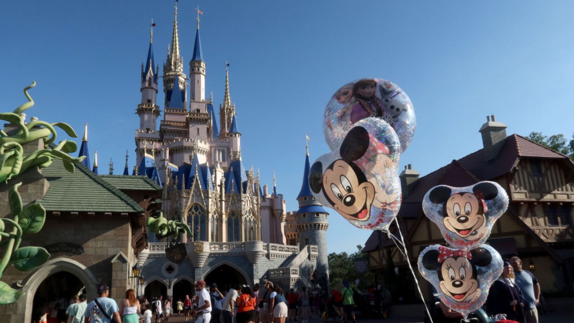 The Disney magic castle with several Mickey Mouse theme balloons in the foreground