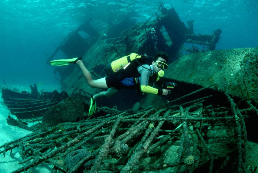 Divers explore an under-water wreck that sits on the ocean floor