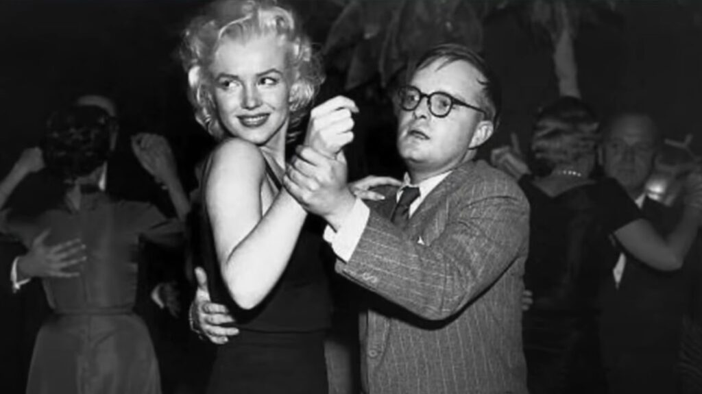 Truman Capote and Marilyn Monroe dancing together. There are other couples also dancing in the background.