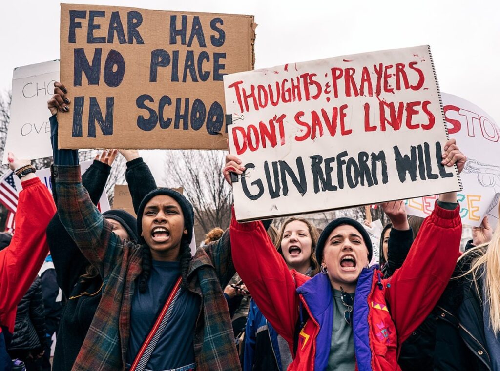 Several people protest for gun reform with signs