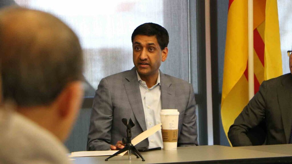 Ro Khanna speaks at a table with a cup of coffee sitting in front of him.