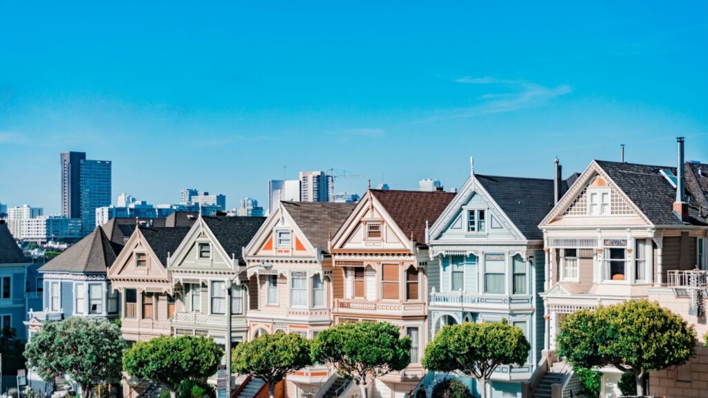 A row of pastel colored houses with trees in front of them in San Francisco, California