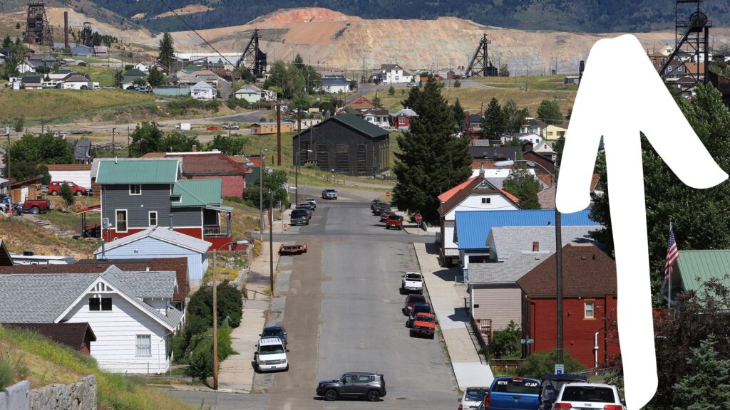 A street in Montana with a white arrow going up alongside it.