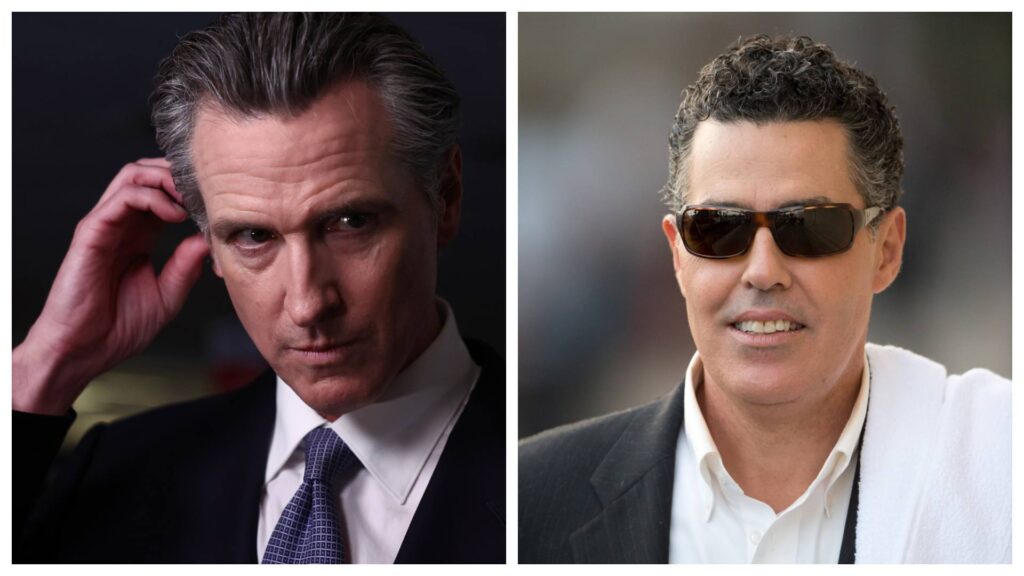 Newsom scratches his head while Adam Carolla smiles while wearing sunglasses.