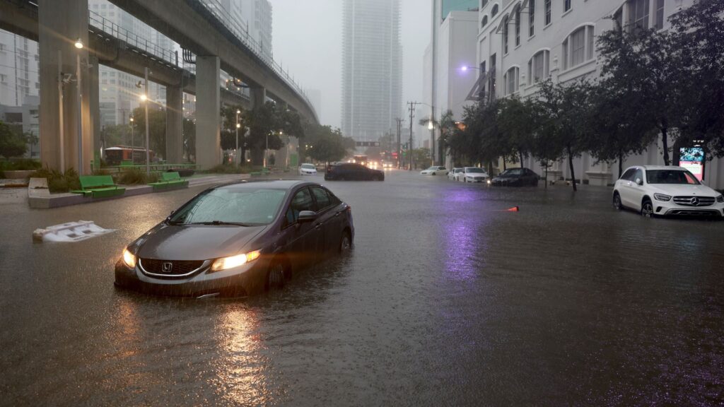 Cars seen in the middle of a flooded road in Miami, Florida.