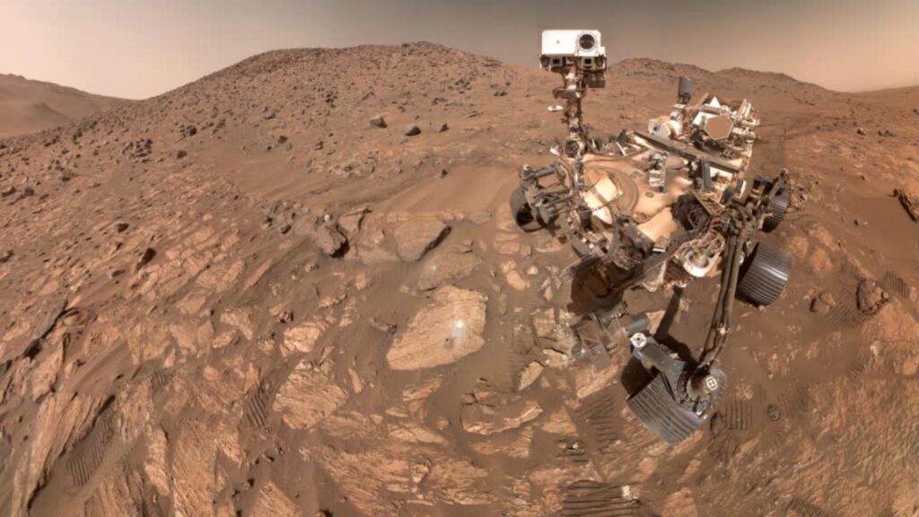 A selfie of the NASA Perseverance rover on Mars with a rock.