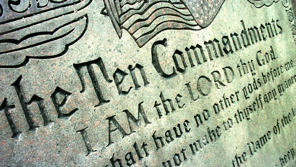 A close-up of a Ten Commandments stone plaque.