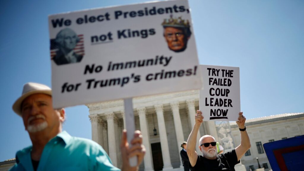 Anti-Trump protestors with signs in front of the Supreme Court