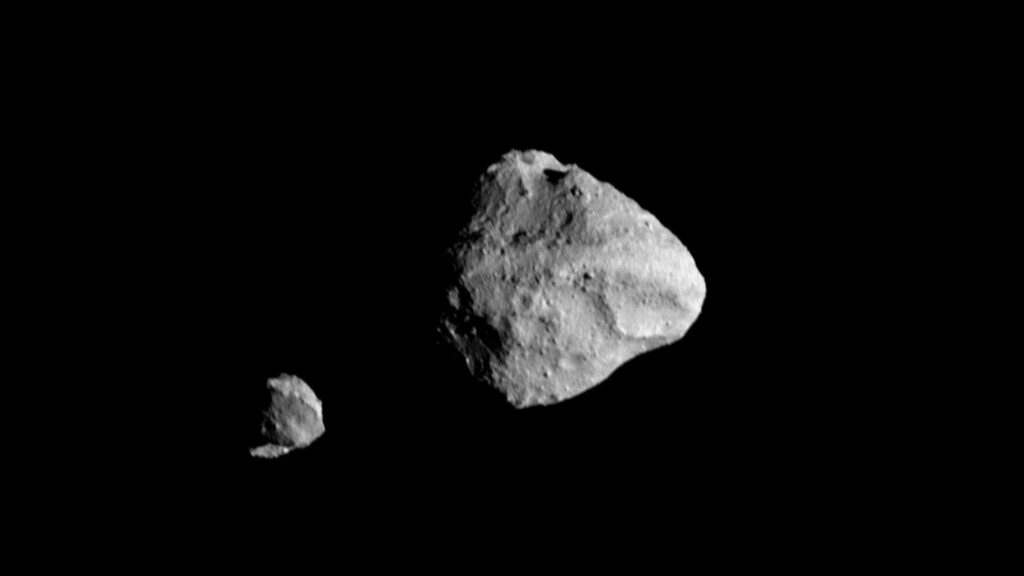 A view of the asteroid Dinkinesh and its satellite in black space.