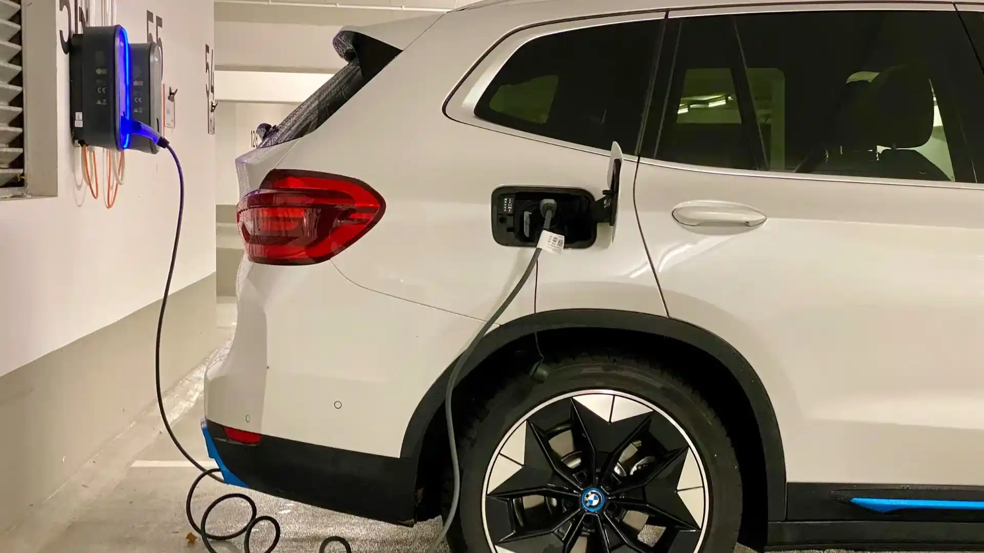 White Hybrid Car Plugged In