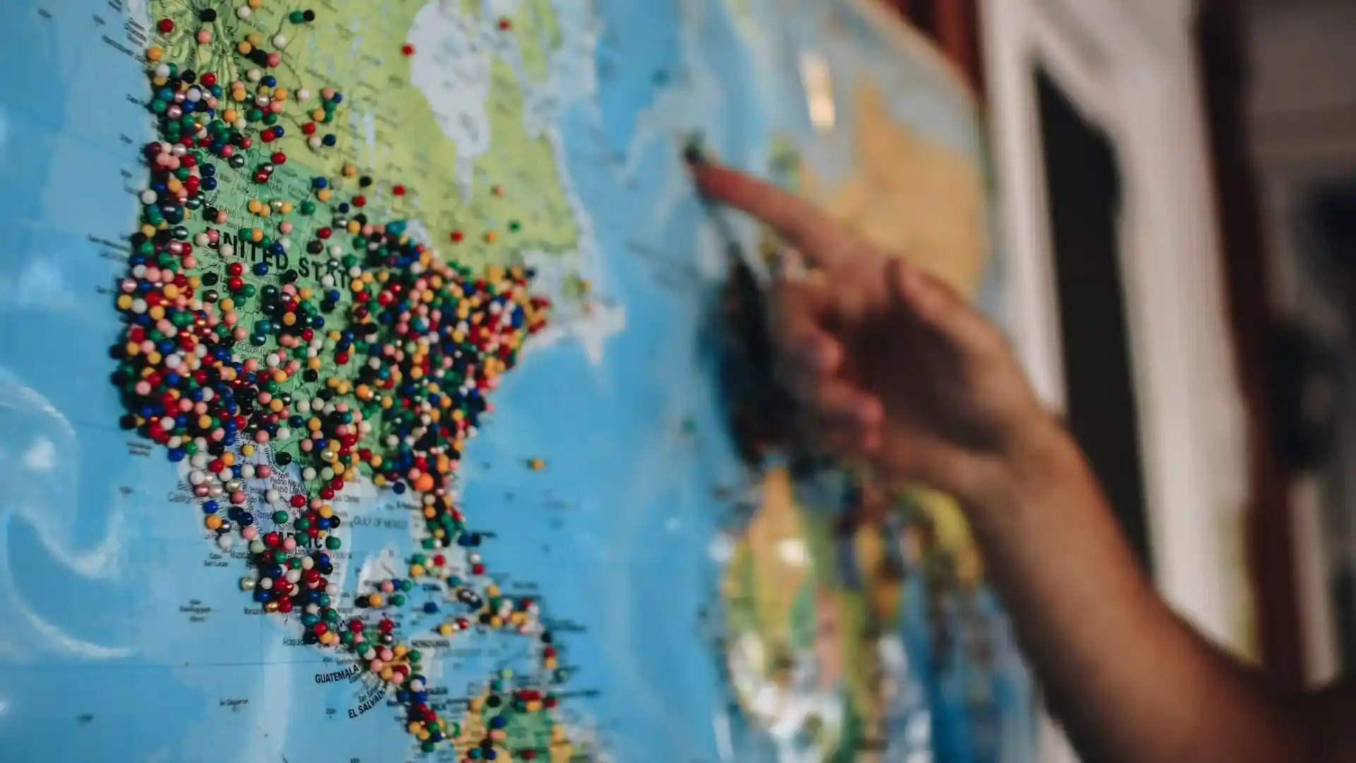 Hand Pointing to Map on a Wall