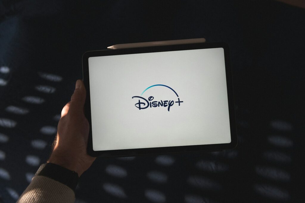 Hand holding a tablet with Disney+ displayed