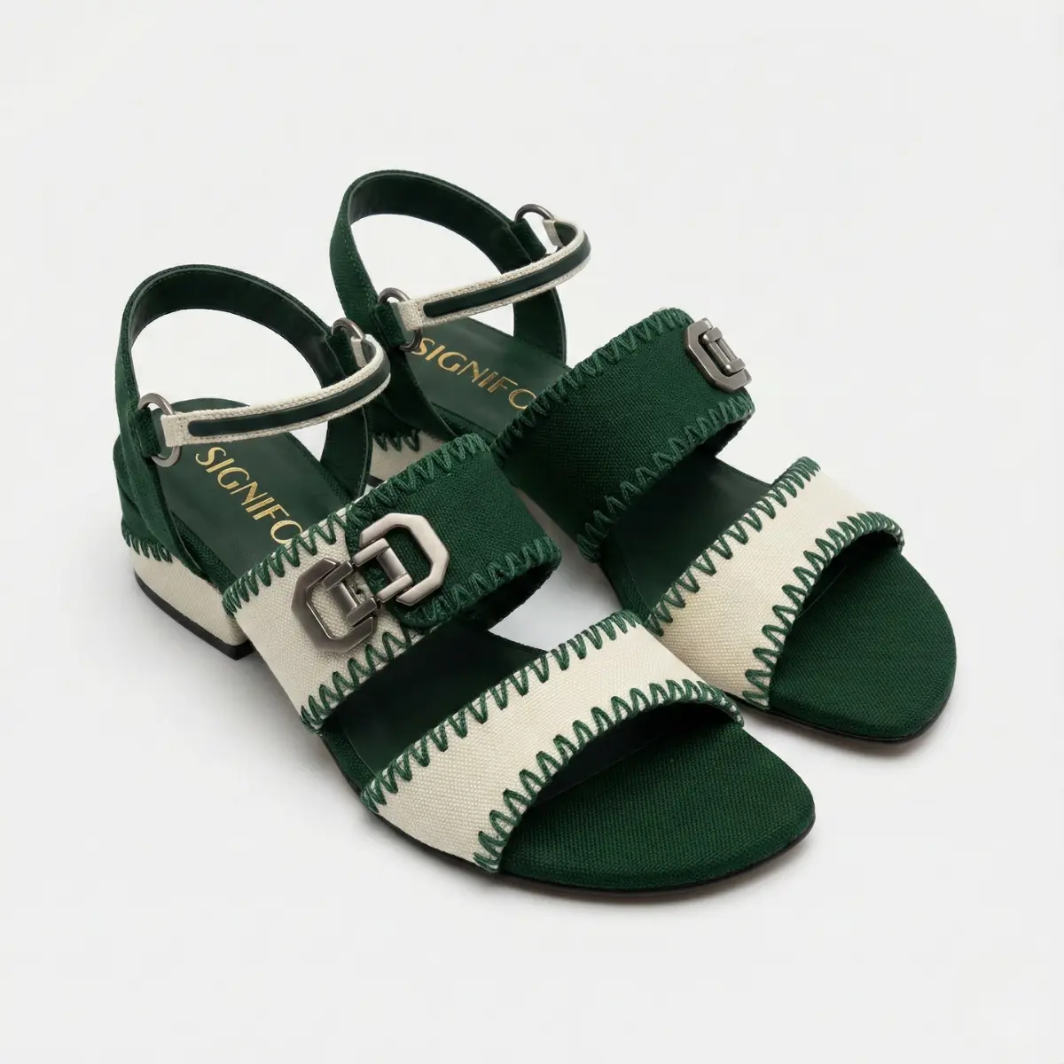 Sepasang sandal Signifo hijau tua-krem dengan hak blok rendah, strap pergelangan kaki, dan detail gesper.