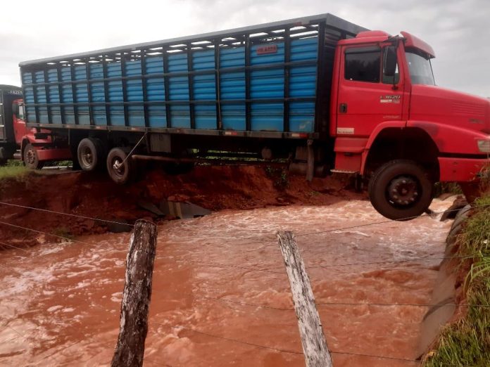Chuva rompe estrada e caminhão fica pendurado