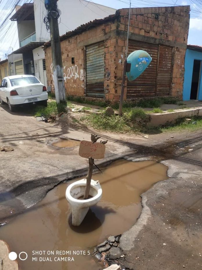 Moradores colocam vaso sanitário para sinalizar buraco no Bacuri