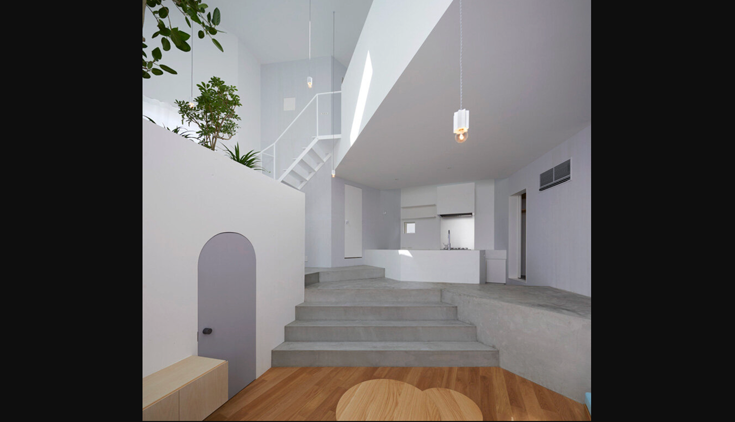 White geometric minimalist house interior with slanted walls and sparse modern detailing