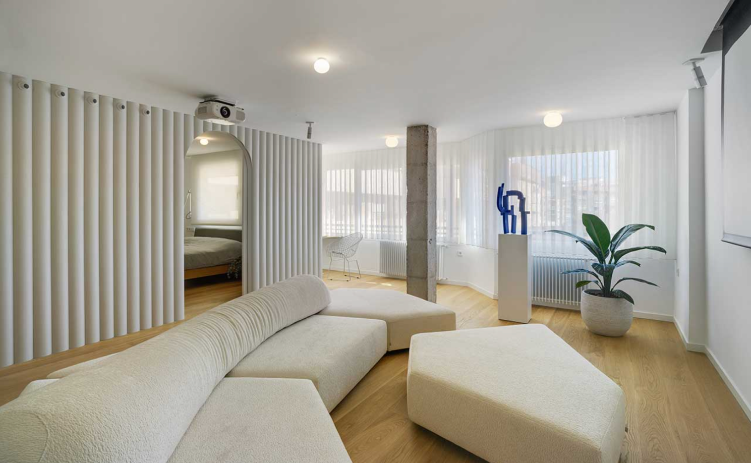 Vertical wood slat accent wall behind a media console with warm LED lighting and neutral modern furniture