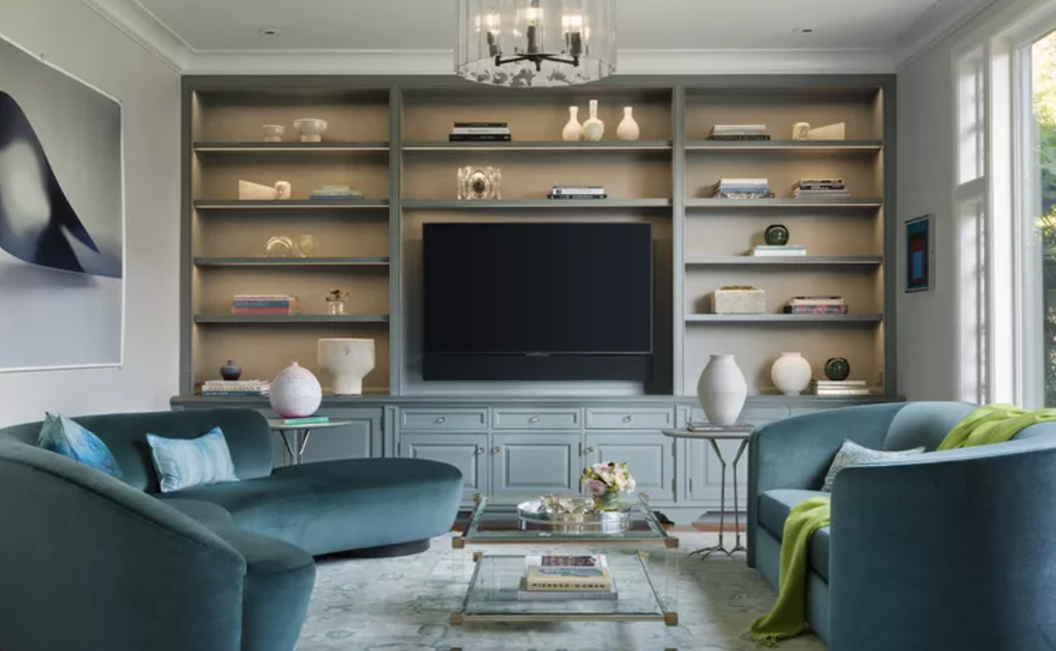 Built-in storage accent wall with closed lower cabinets, open shelves, and warm wood paneling
