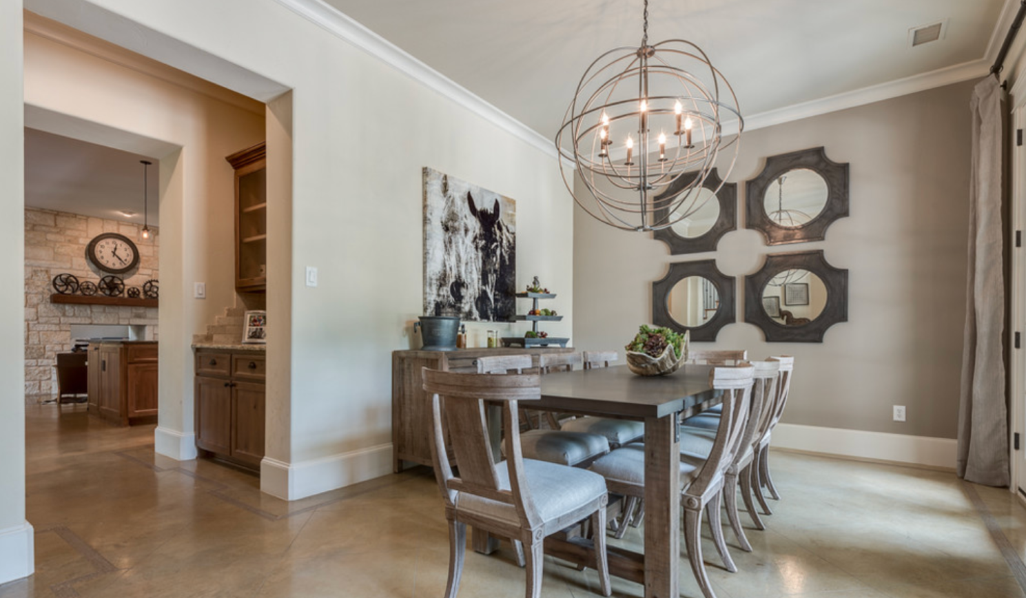 Entryway accent wall with a large antique mirror, slim console table, wall sconces, and warm neutral paint