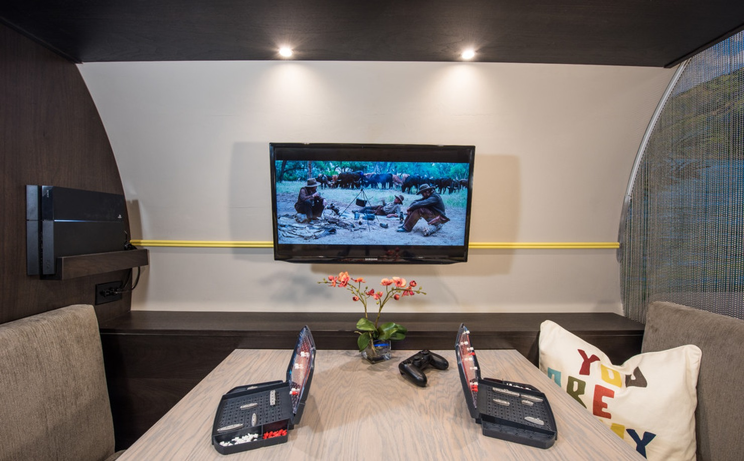 Small kids’ game room with wall-mounted TV, carpet, gray walls, and compact seating