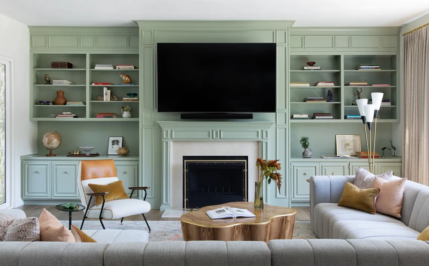 Family lounge with sectional sofa, oversized coffee table, board games, throw pillows, and warm lighting
