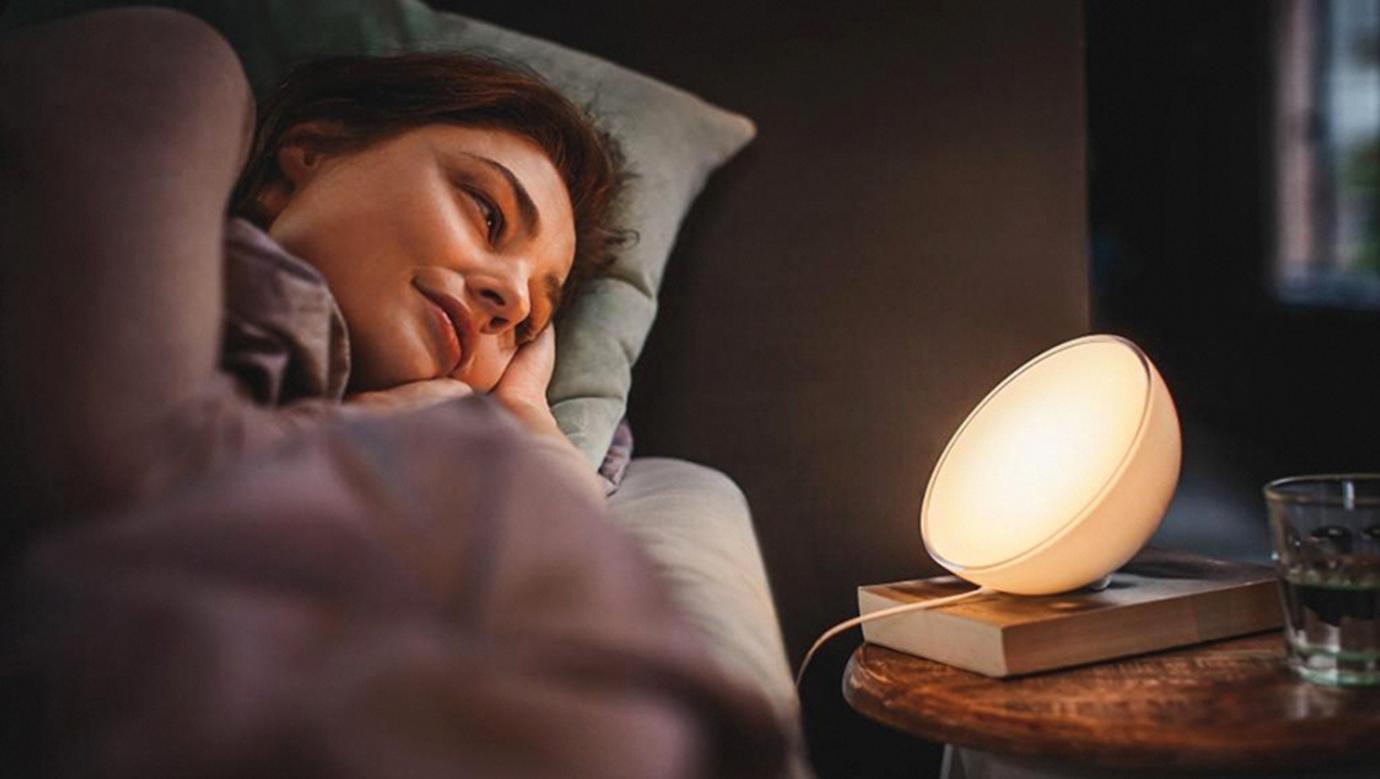 A soft warm bedside wellness lamp supports relaxation and better sleep