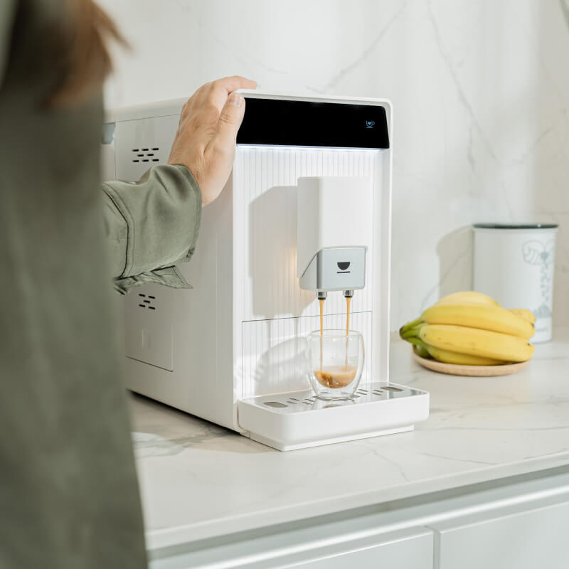 Cafetera superautomática INCAPTO Aura blanca preparando un espresso en un vaso de doble pared con su doble salida de café