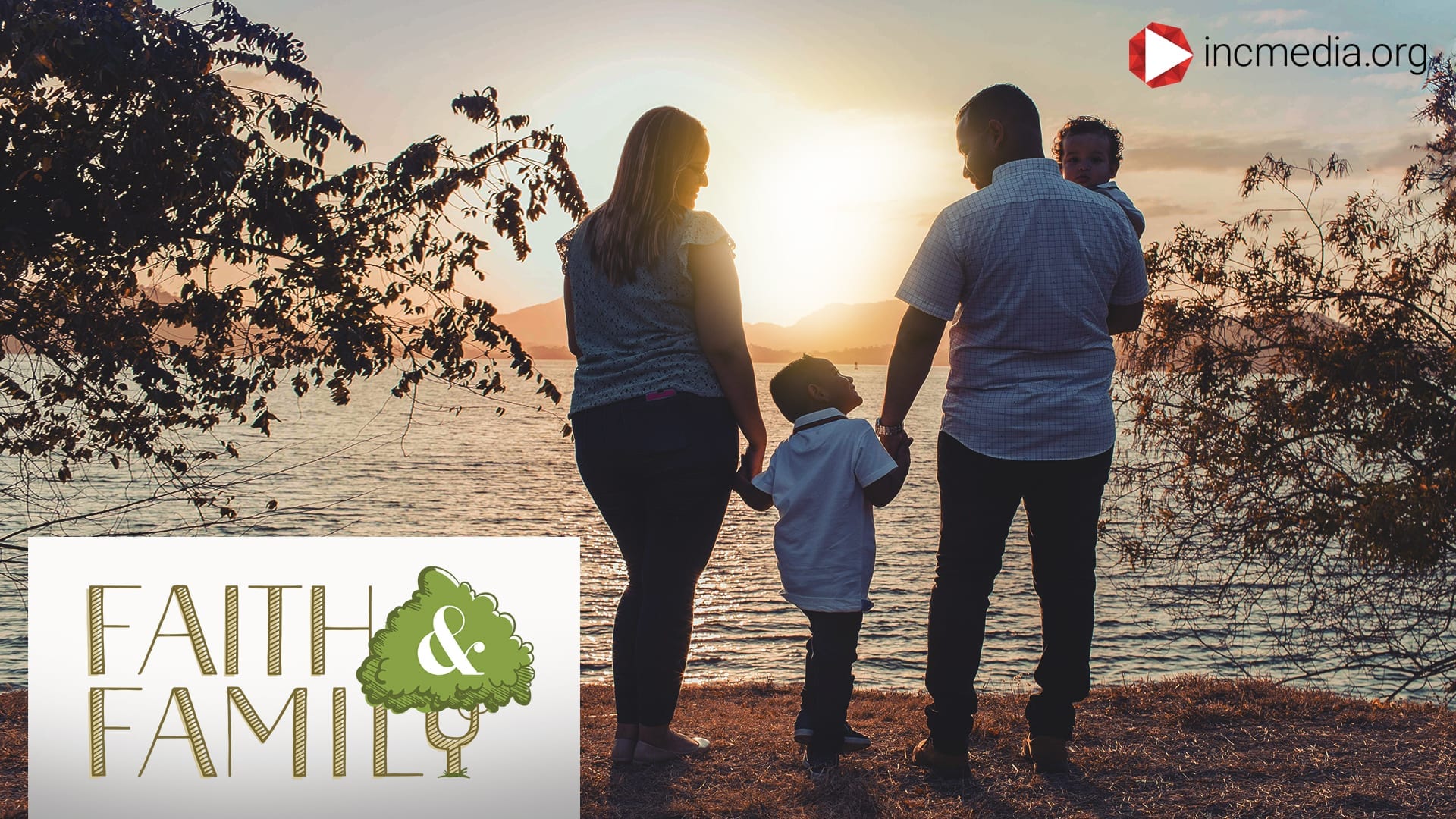 father and mother holding hands with their 2 kids in front of the water