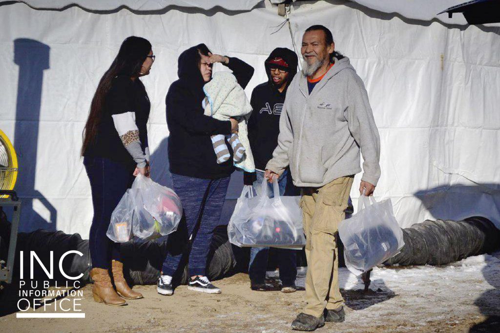 man carrying winter relief packages leaves the event tent