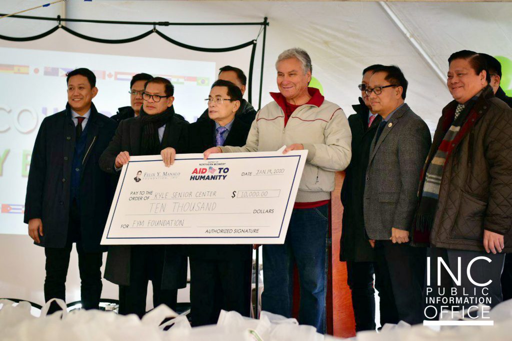 Roy Martinez, Sr., of the Kyle Senior Center accepting a donation from the Felix Y. Manalo Foundation for $10,000, presented by INC General Auditor Brother Glicerio Santos, Jr.  for their work in the community. 
