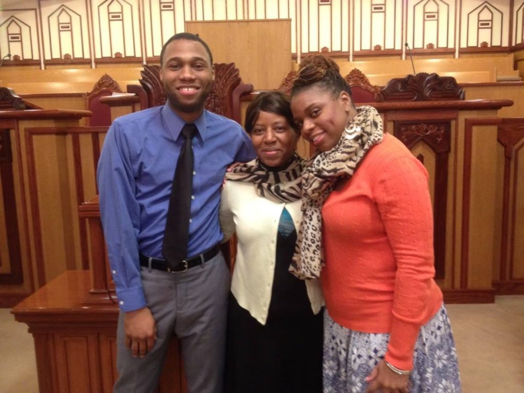 Young man with mom and sister in front of a podium
