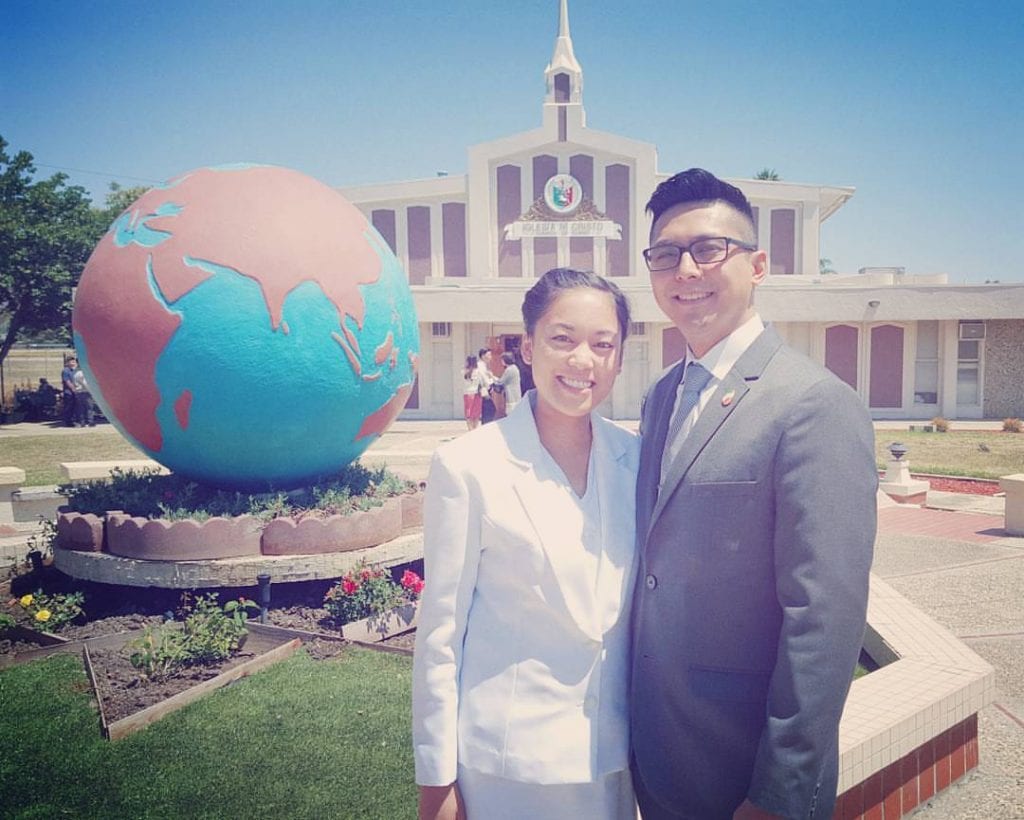 husband and wife in front of the chapel