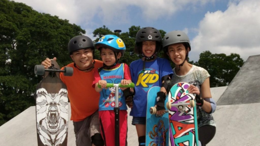 Family of four on skateboards.