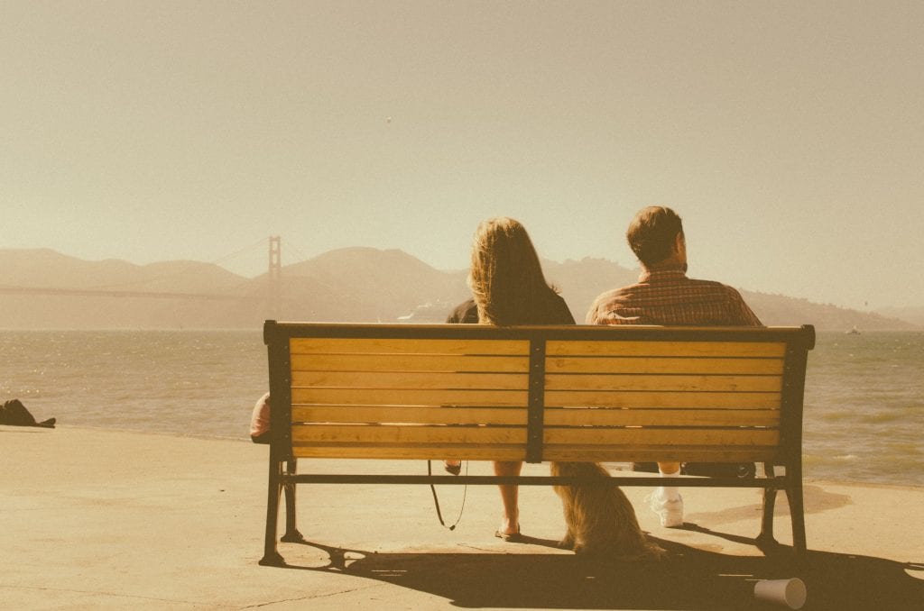 Couple sitting on a bench looking out to Golden Gate Bridge