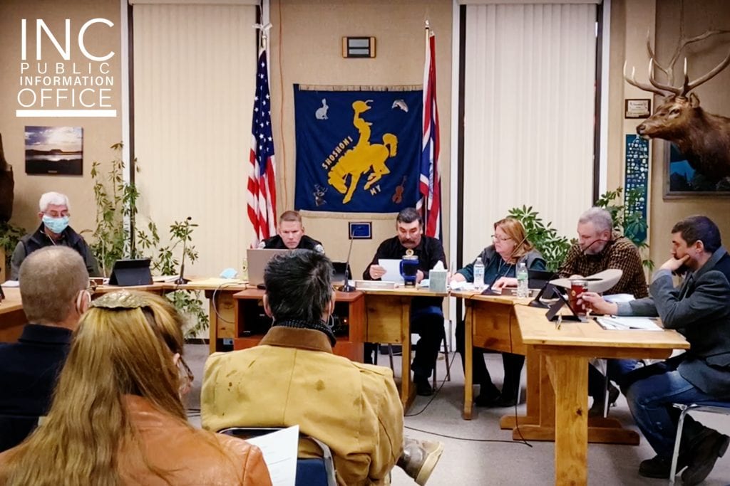 Council members sitting behind a desk during a town hall meeting