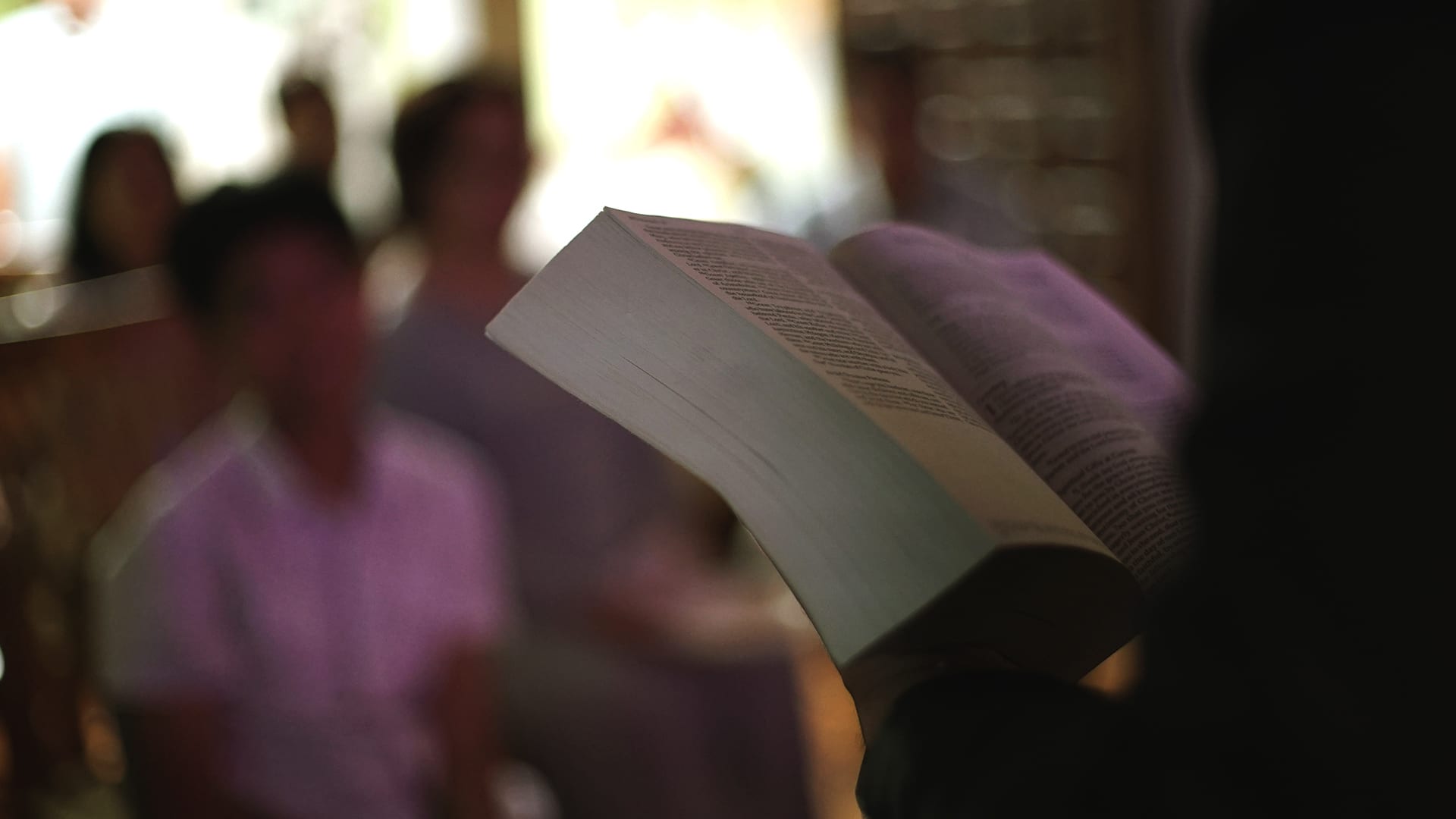 close up shot of hands holding an open bible