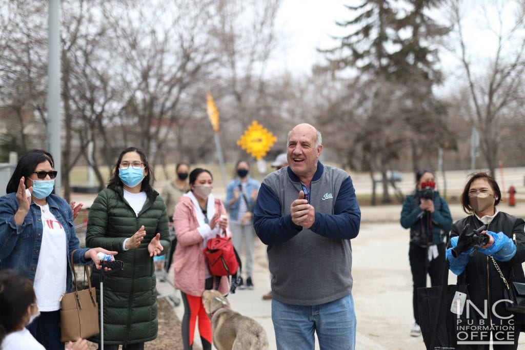 man smiles alongside volunteers as red river area