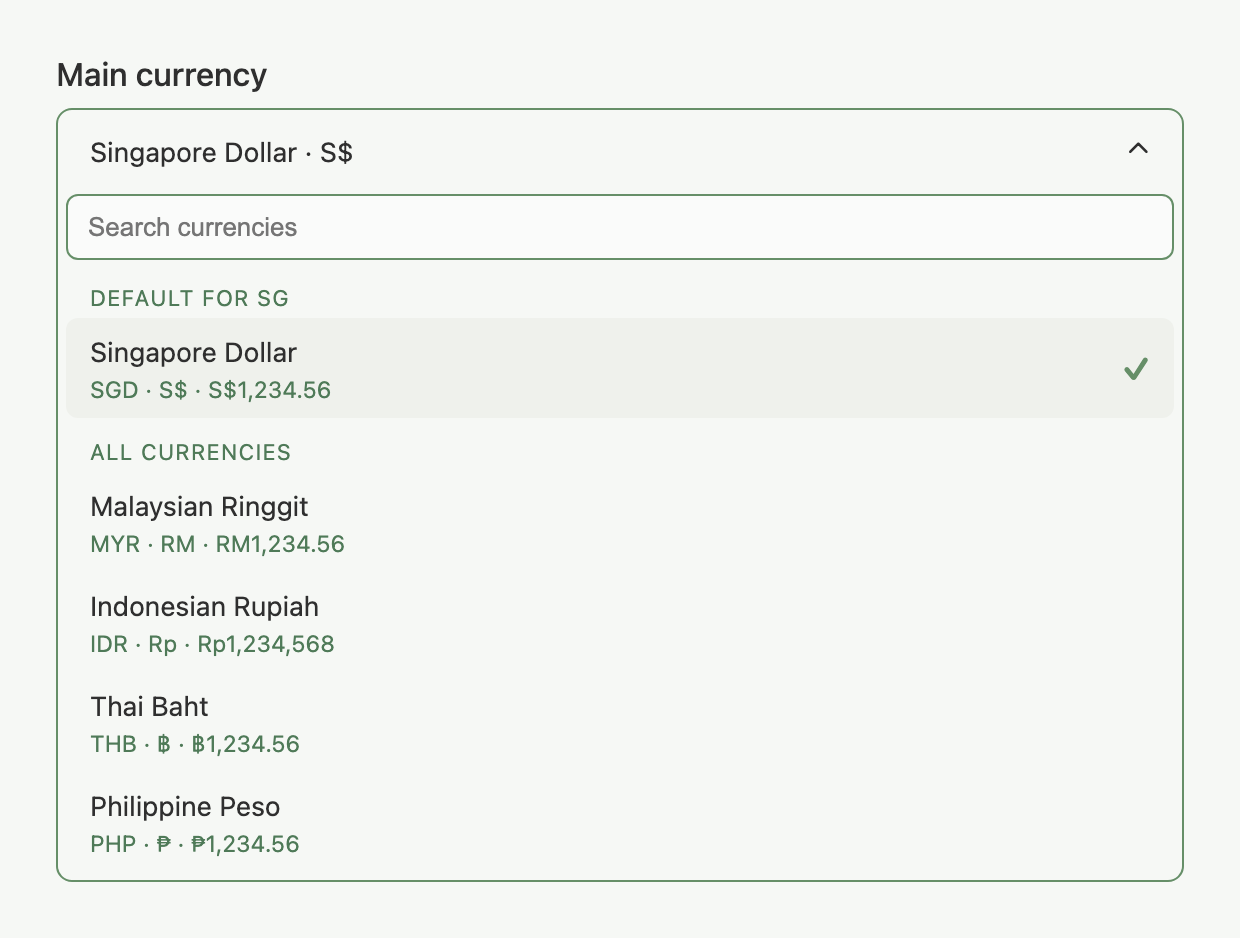 Main currency dropdown open, showing the DEFAULT FOR SG and ALL CURRENCIES groups with a search box and sample-amount formatting