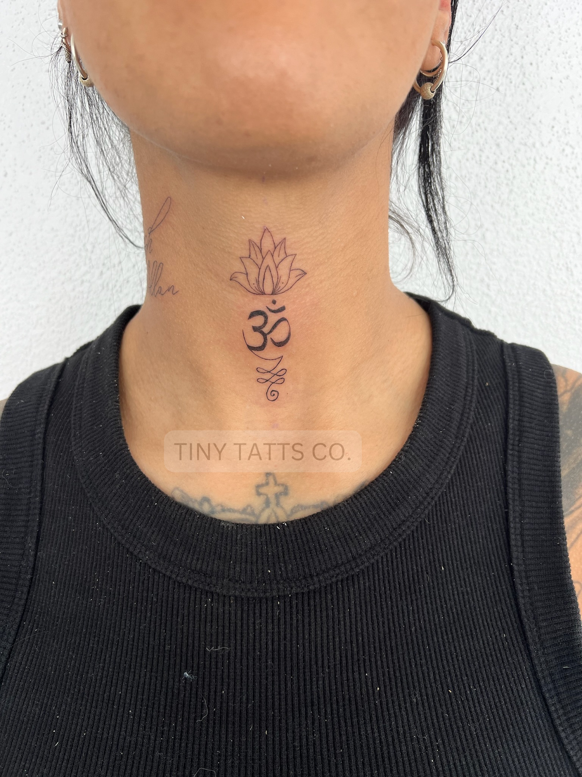 A detailed linework lotus tattoo with sacred geometry elements on the neck.