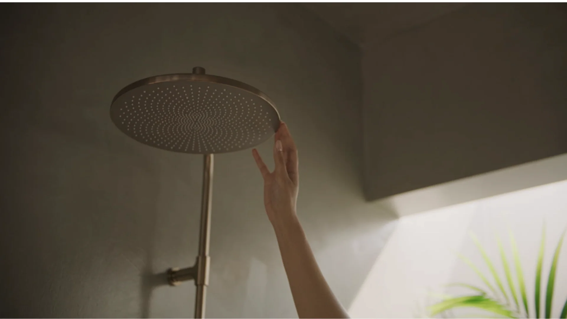 Swiveling the brushed bronze Aurelia overhead shower