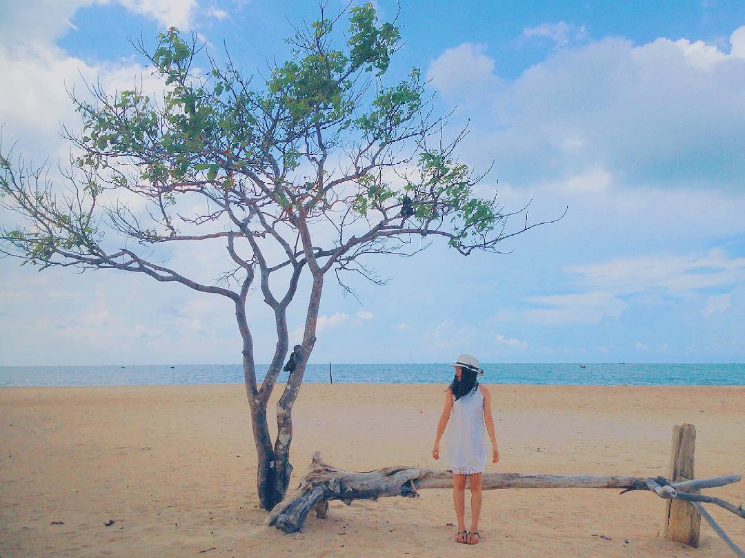 A girl posing on the sand by the beach