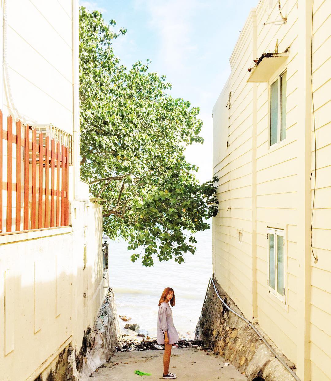 A girl posing along the alley leading to a beach