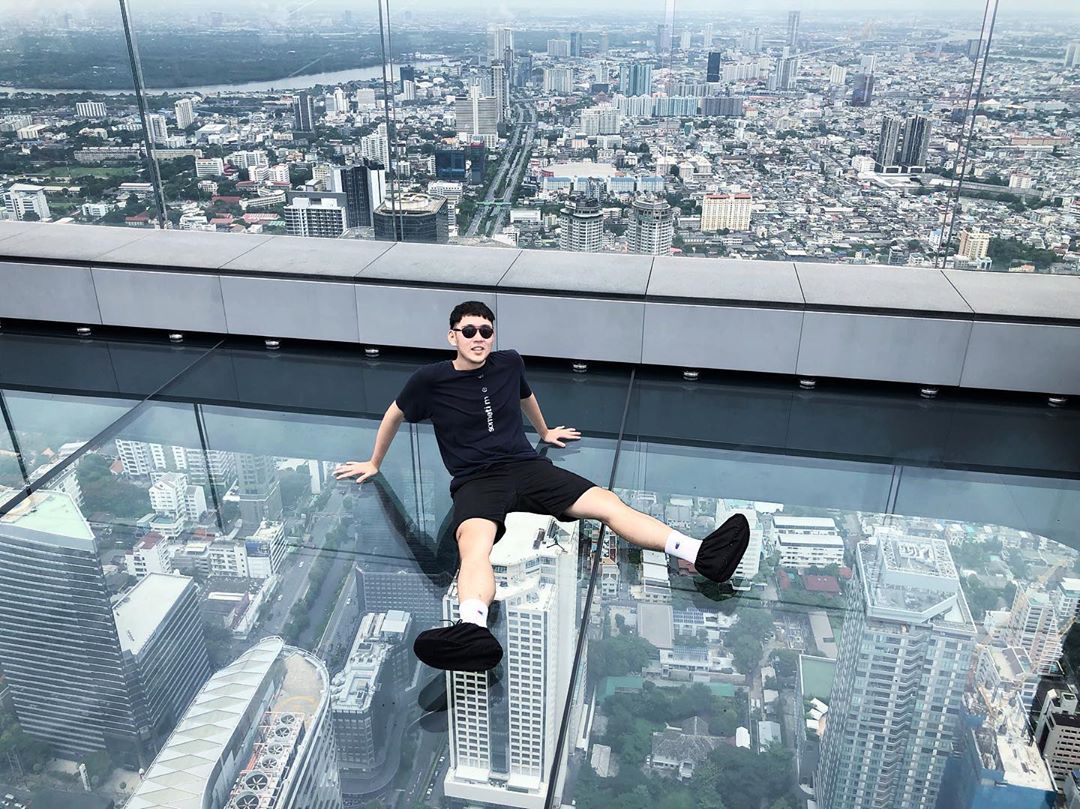 A guy posing on the glass tray-paved Mahanakhon Skywalk