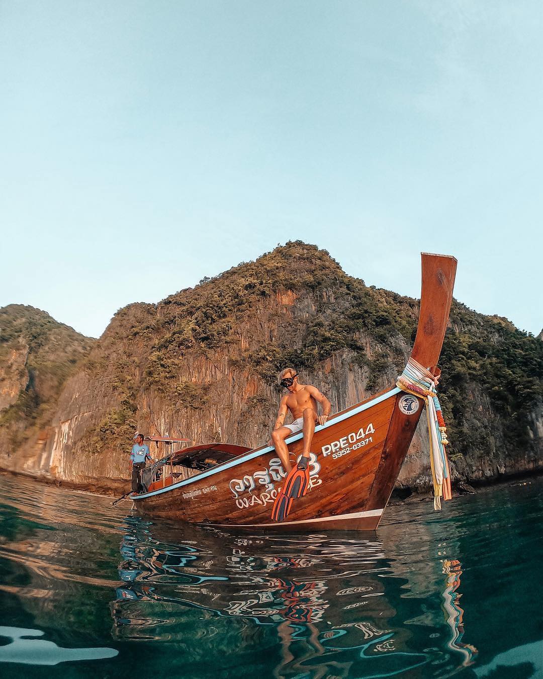 A male traveler sitting on a boat during his travel to Thailand