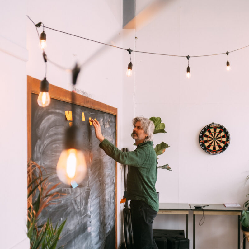 Man aan krijtbord tijdens brainstorm