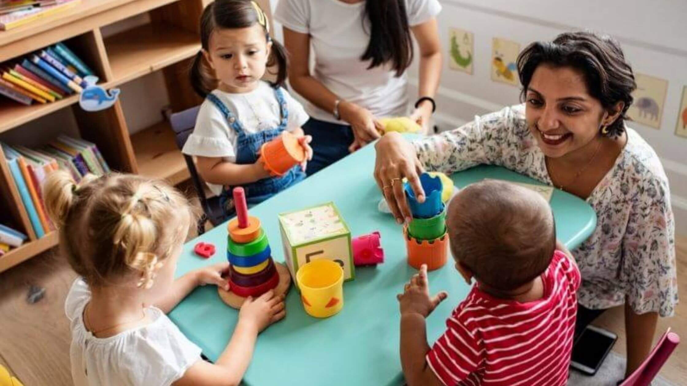 Woman playing with children who are spending the day at a top daycare franchise.