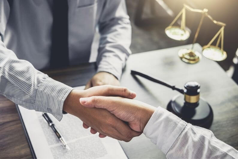 Businessman shakes hands with franchise attorney he just hired.