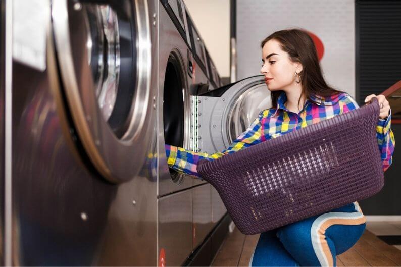 Woman loads clothes into washer at a popular laundromat franchise