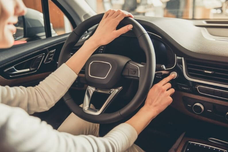 A customer test drives her future car at a dealership specialty franchise.